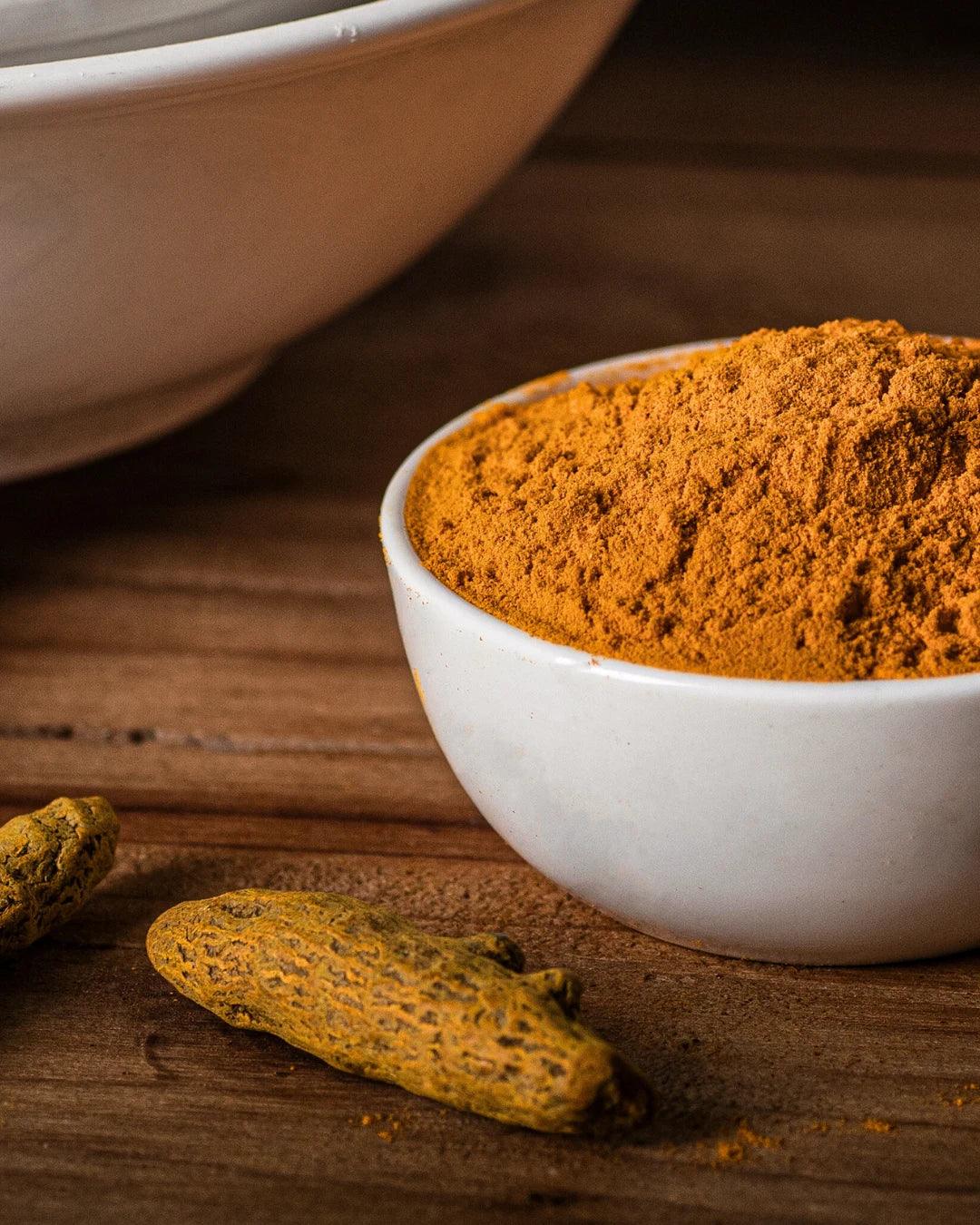 Bright yellow turmeric powder online served in a small bowl 