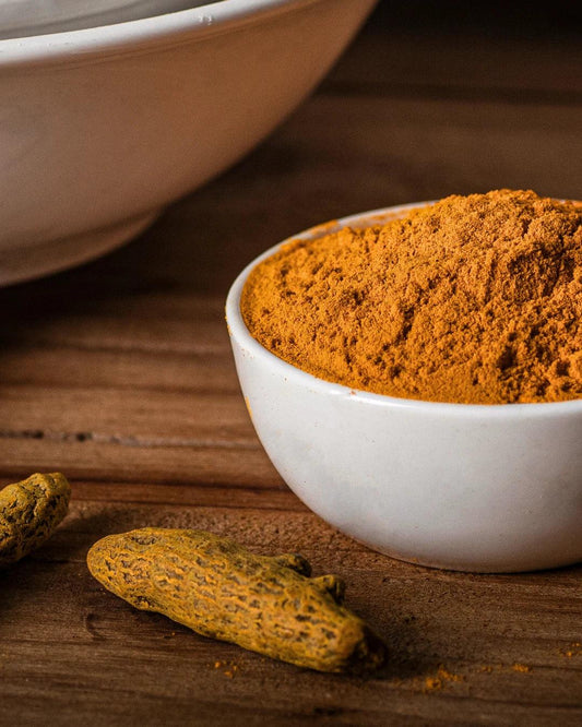 Bright yellow turmeric powder online served in a small bowl 
