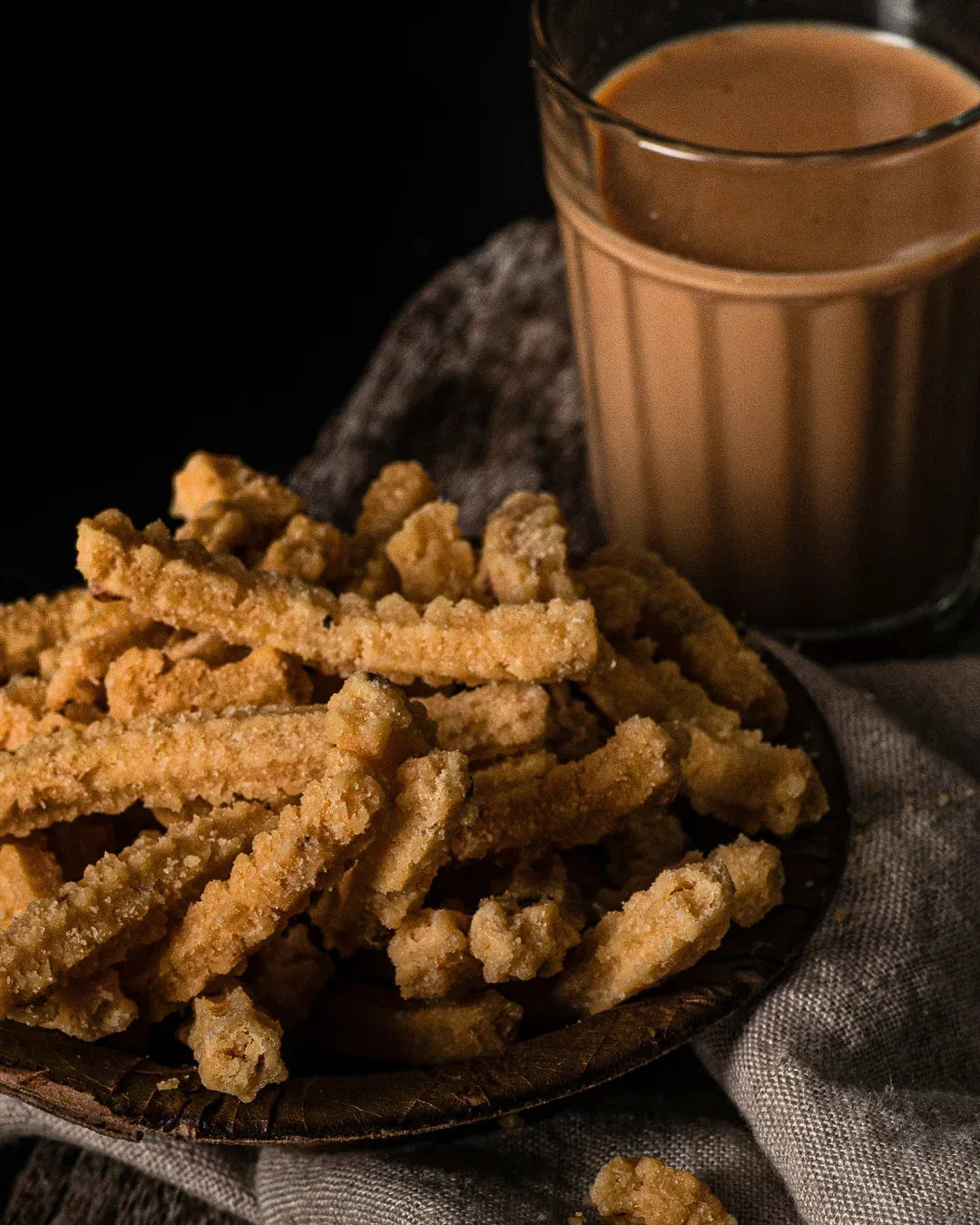 Shiny butter murukku served in a small bowl on a leaf